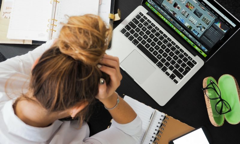 Girl at a desk with laptop and phone
