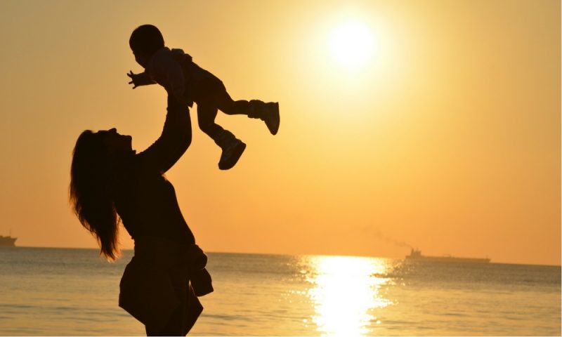 Lady raising baby to sunlight