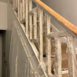 The spindles of the staircase with the Kling Strip applied and covered in cling film.